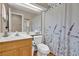 Bathroom with a white shower curtain, a toilet, a mirror, and a sink with wood paneling at 4628 Standing Bluff Way, Las Vegas, NV 89130
