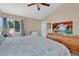 A bright and airy bedroom featuring a bed, large window, and dresser with a mounted television at 4628 Standing Bluff Way, Las Vegas, NV 89130