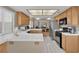 Well-lit kitchen with white tiled countertops, tile flooring, stainless steel appliances, and honey oak cabinets at 4628 Standing Bluff Way, Las Vegas, NV 89130
