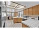 Well-lit kitchen with white tile countertops, wood cabinets, and a view of the dining area through the windows at 4628 Standing Bluff Way, Las Vegas, NV 89130