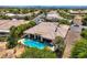 Aerial shot including a well-kept lawn, a sparkling pool, covered patio and beautiful home at 4719 Riva De Romanza St, Las Vegas, NV 89135