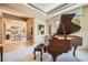 Elegant living room featuring a grand piano and open access to the formal dining area at 4719 Riva De Romanza St, Las Vegas, NV 89135