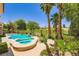 Beautiful backyard pool with a spa, palm trees, and views of the green golf course at 4719 Riva De Romanza St, Las Vegas, NV 89135