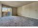 Spacious carpeted living room featuring a large window letting in natural light at 4943 Indian River Dr # 133, Las Vegas, NV 89103