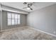 Bright bedroom featuring neutral carpet, plantation shutters, and a ceiling fan at 5417 Eastbrook Dr, Las Vegas, NV 89142
