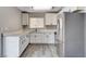 Bright kitchen featuring white cabinets, gray-toned wood flooring, stone countertops, and stainless steel appliances at 5417 Eastbrook Dr, Las Vegas, NV 89142