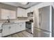 Updated kitchen boasts stainless steel appliances, white cabinetry, stone countertops, and modern fixtures at 5417 Eastbrook Dr, Las Vegas, NV 89142