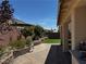 Outdoor patio with stone pavers, a manicured lawn, and a wall of mature trees at 6454 Mount Palomar Ave, Las Vegas, NV 89139