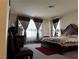 Cozy bedroom with a luxurious bed, decorative curtains, and a dresser at 6454 Mount Palomar Ave, Las Vegas, NV 89139