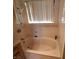Bathroom featuring large tub, marble-style wall, and handheld shower at 671 Bourbon St, Pahrump, NV 89048