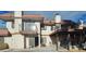 Beige, two-story condo with a red tile roof, balcony, and covered patio at 671 Bourbon St, Pahrump, NV 89048