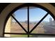 View through large rounded window showing mountains and a tree on a clear day at 671 Bourbon St, Pahrump, NV 89048