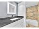 Modern bathroom featuring a stone tiled shower, white vanity and a large mirror at 6717 Sheffield Dr, Las Vegas, NV 89108