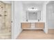 Modern bathroom featuring double sinks, wood cabinets, a glass shower, and updated fixtures at 6717 Sheffield Dr, Las Vegas, NV 89108