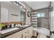 Bathroom featuring double sinks, tile backsplash, and shower with tile surround at 6821 Jeanette St, Las Vegas, NV 89131