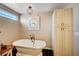 Stylish bathroom with a soaking tub, glass block window, and vintage fixtures at 6821 Jeanette St, Las Vegas, NV 89131