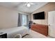 Neutral bedroom features carpet, ceiling fan, window, dresser and mounted television at 6821 Jeanette St, Las Vegas, NV 89131