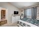 Well-lit bedroom with a window, a mirror, and dresser storage with decorative items at 6821 Jeanette St, Las Vegas, NV 89131