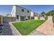 Large backyard featuring artificial grass, mature landscaping, and string lights at 7382 Elbridge Way, Las Vegas, NV 89113