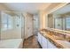 Luxurious main bathroom with double sinks, granite counters, separate shower and tub, and updated lighting at 7382 Elbridge Way, Las Vegas, NV 89113
