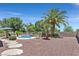 Secluded backyard featuring a refreshing pool, mature palm trees, and a serene outdoor seating area at 7408 Via Fiorentino St, Las Vegas, NV 89131