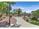 Landscaped backyard with a sparkling pool and mature palm trees at 7408 Via Fiorentino St, Las Vegas, NV 89131