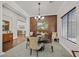 Formal dining room features wood accent wall, stylish lighting and neutral decor at 7408 Via Fiorentino St, Las Vegas, NV 89131