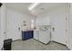 Bright laundry room features a washer, dryer, and a blue cabinet under the sink at 7408 Via Fiorentino St, Las Vegas, NV 89131