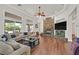 Bright living room with a stacked stone fireplace, large windows, hardwood floors and a comfortable sectional sofa at 7408 Via Fiorentino St, Las Vegas, NV 89131