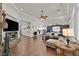 Spacious living area showcasing hardwood floors, tray ceilings, a stone fireplace and open layout with sightlines to the kitchen at 7408 Via Fiorentino St, Las Vegas, NV 89131