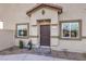Close up of a home's covered front entry with a modern door, manicured landscaping, and brick steps at 7945 Pandora Sky St # 3, North Las Vegas, NV 89084