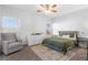 Bright bedroom featuring a cozy armchair, a comfortable bed, and a ceiling fan at 8036 Eurostar St, Las Vegas, NV 89131