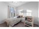 Well-lit bedroom with a day bed and crib, showcasing natural light from a window at 8036 Eurostar St, Las Vegas, NV 89131