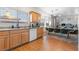 Open kitchen and dining area with wood floors, light wood cabinets, and stainless steel sink at 8036 Eurostar St, Las Vegas, NV 89131