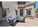 Inviting front yard features a beautiful blue door with comfortable outdoor seating on a brick patio at 8204 Chimney Bluffs St, North Las Vegas, NV 89085