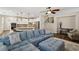 Open-concept living room featuring a comfortable blue sectional sofa and a view of the modern kitchen at 8204 Chimney Bluffs St, North Las Vegas, NV 89085