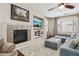 Relaxing living room featuring a fireplace, large TV, hardwood floors, and comfortable couches at 8204 Chimney Bluffs St, North Las Vegas, NV 89085