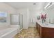 Bright bathroom featuring double sinks, a tub, and a separate glass shower at 8224 Fowler Falls Ct, North Las Vegas, NV 89085
