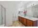 Bright bathroom featuring double sinks, a shower, and neutral-toned flooring at 8224 Fowler Falls Ct, North Las Vegas, NV 89085