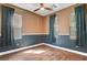 Corner bedroom with three windows, neutral paint, an overhead fan, and wood look tile flooring at 8560 Alocasia Ct, Las Vegas, NV 89149