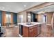 View of the kitchen with tile floors, a center island, stainless appliances and an adjacent dining area at 8560 Alocasia Ct, Las Vegas, NV 89149