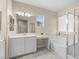 Inviting bathroom featuring a large mirror, vanity, bathtub with shower and soft, neutral colors at 9053 Boston Springs Ave, Las Vegas, NV 89149