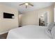 Bedroom featuring hardwood floors, neutral color palette, ceiling fan and wall-mounted television at 9053 Boston Springs Ave, Las Vegas, NV 89149