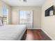 Neutral-toned bedroom featuring hardwood floors, a large window, and ample natural light at 9053 Boston Springs Ave, Las Vegas, NV 89149