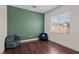 Cozy bedroom with hardwood floors, a large window, and a comfortable beanbag chair at 9053 Boston Springs Ave, Las Vegas, NV 89149