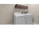 Functional laundry room equipped with modern washer and dryer and storage shelves above at 9053 Boston Springs Ave, Las Vegas, NV 89149
