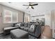Bright living room with a plush gray sectional sofa and open access to the modern white kitchen at 9053 Boston Springs Ave, Las Vegas, NV 89149