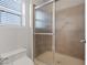 Bathroom featuring a frosted glass enclosed shower and toilet beneath a window at 9105 Marble Dr, Las Vegas, NV 89134