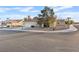 Well-manicured lawn, attractive landscaping, with a glimpse of the home, garage, and tile roof in a serene neighborhood at 9105 Marble Dr, Las Vegas, NV 89134