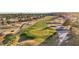 Close aerial view of a lush green golf course with a manicured green and bunkers surrounded by trees and landscaping at 9105 Marble Dr, Las Vegas, NV 89134